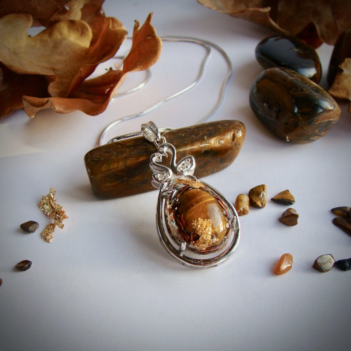 Pendentif orgonite oeil de tigre serti cygnes