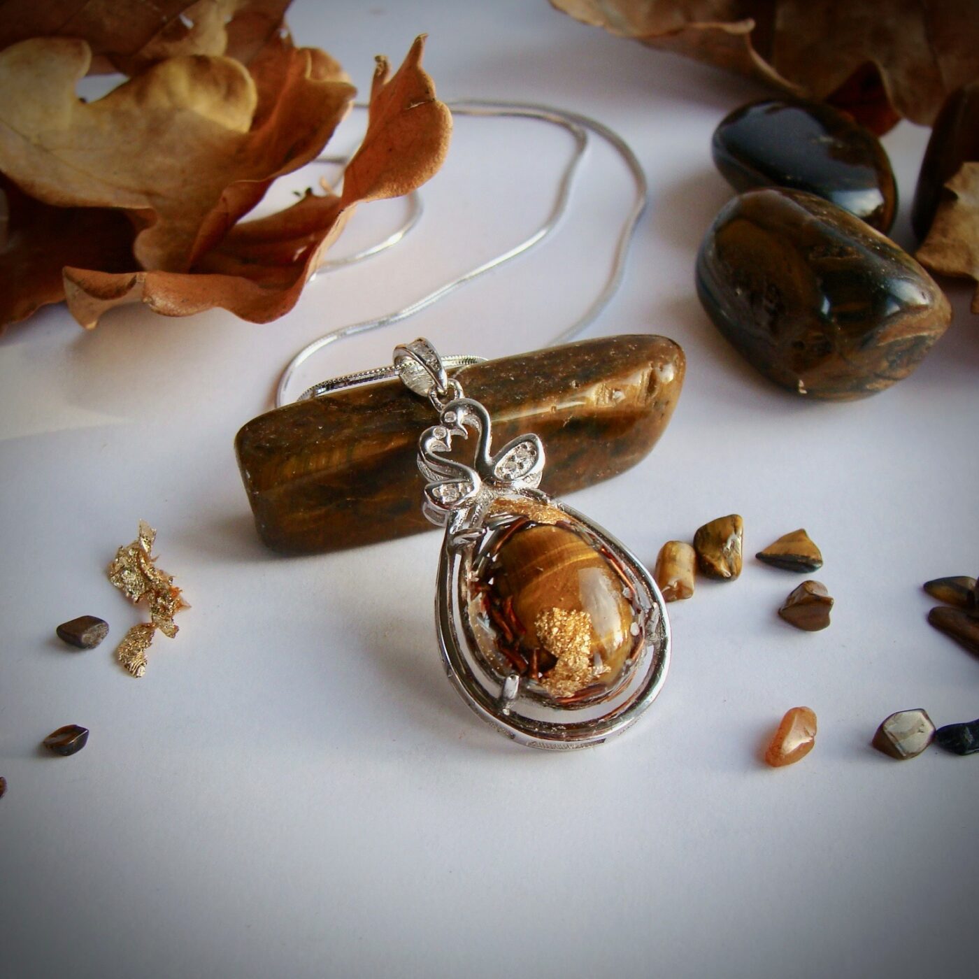 Pendentif orgonite oeil de tigre serti cygnes